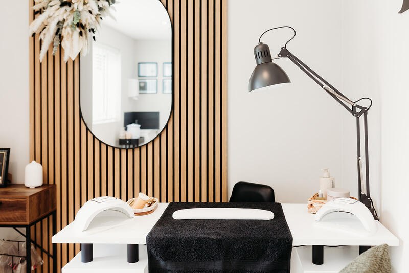 The nail station by the oak-slatted wall