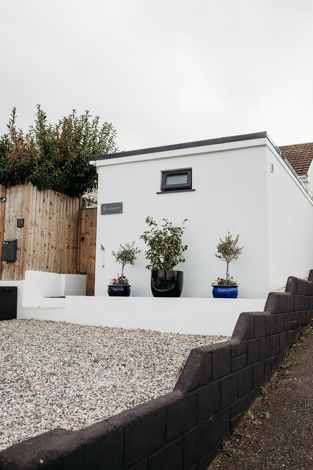 The white garage conversion clinic on Valley View with potted olive trees