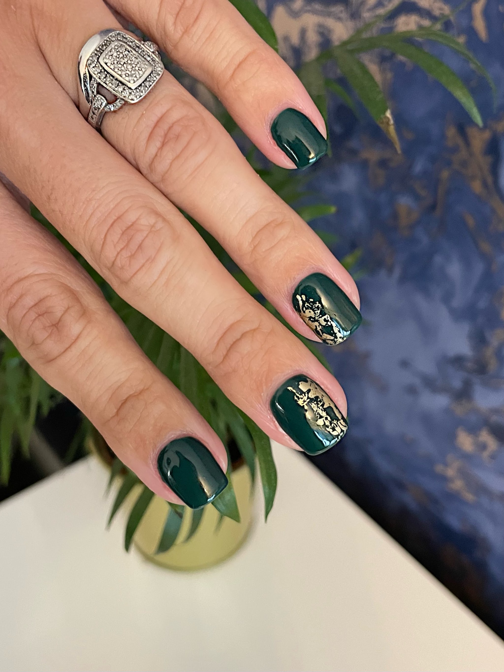 Dark green gel nails with gold foil accents